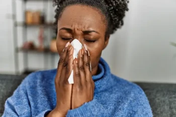 Woman blowing her nose too hard